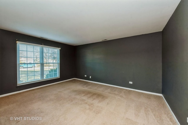 spare room featuring light colored carpet