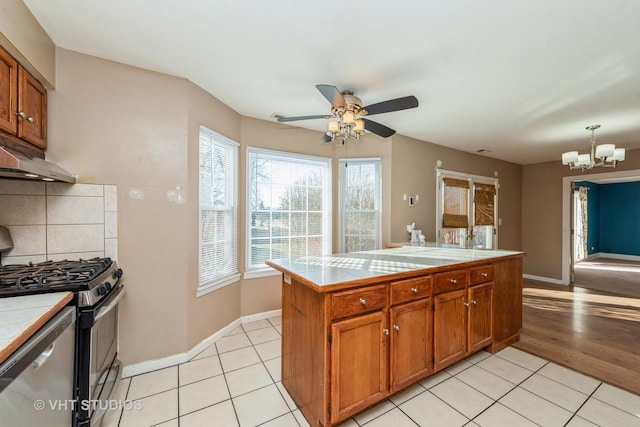 kitchen featuring gas stove, tile countertops, dishwasher, and light tile patterned floors