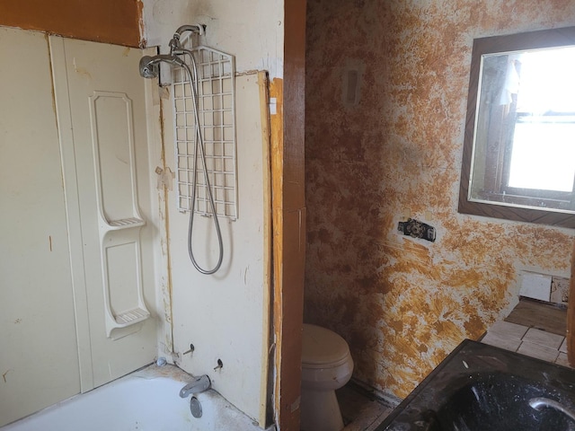 bathroom featuring shower / bathing tub combination and toilet