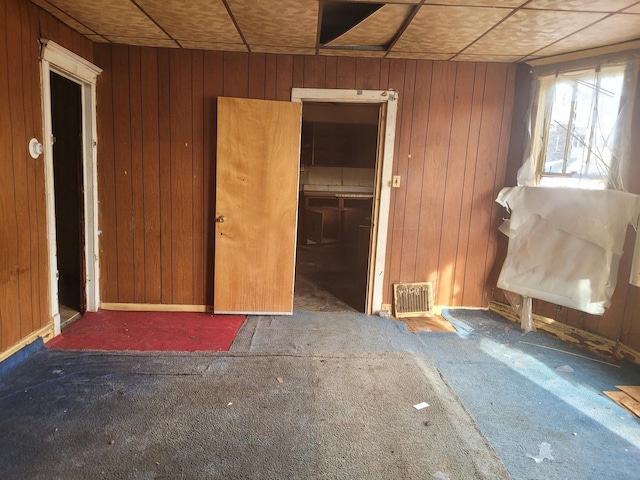 misc room featuring wood walls and dark carpet