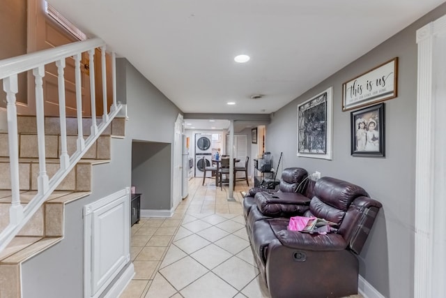 tiled living room with stacked washer and dryer