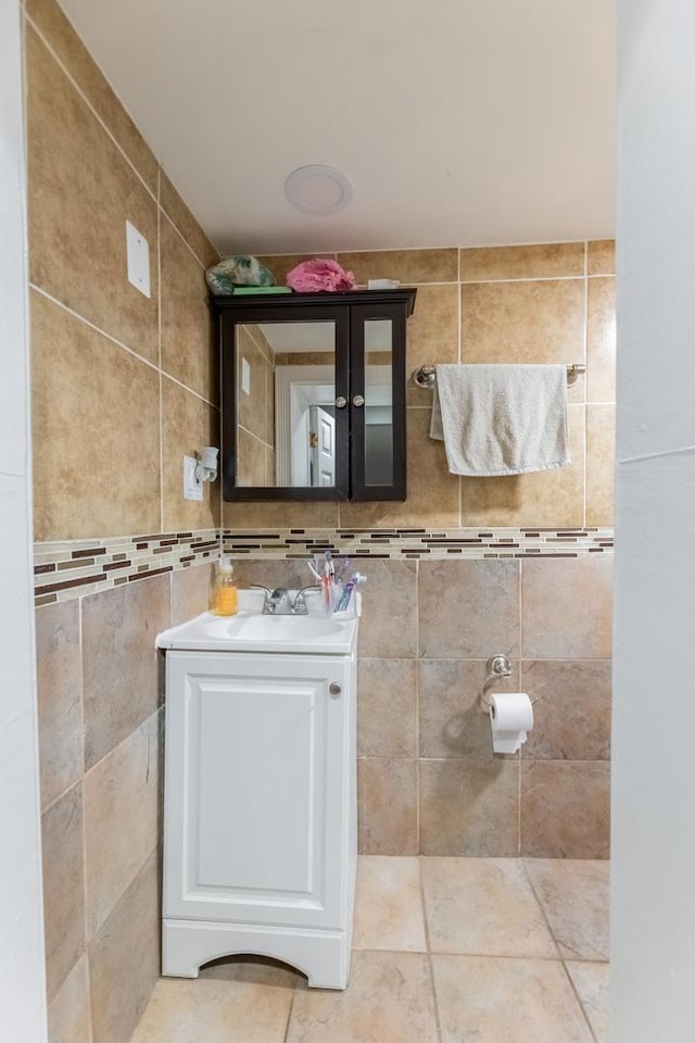 bathroom featuring vanity and tile walls