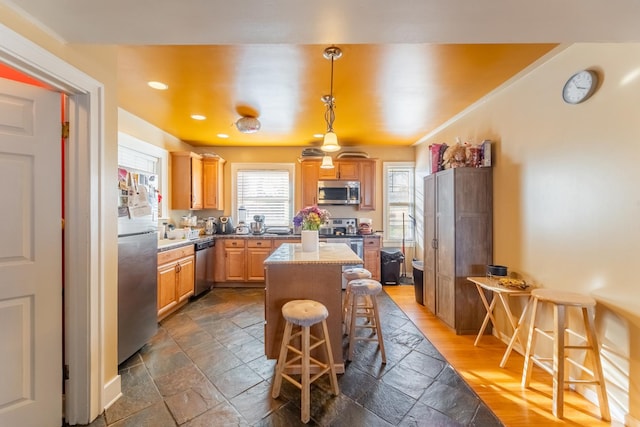 kitchen featuring pendant lighting, a center island, a breakfast bar area, and appliances with stainless steel finishes