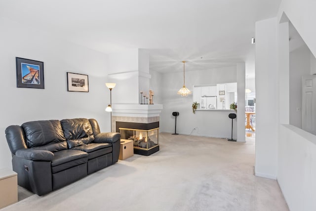 living room featuring a tile fireplace and light colored carpet