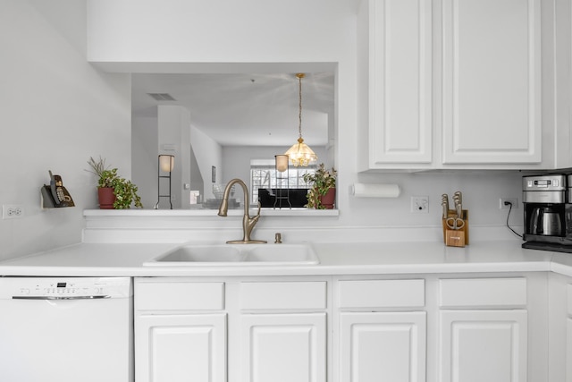 kitchen featuring decorative light fixtures, white dishwasher, white cabinetry, and sink