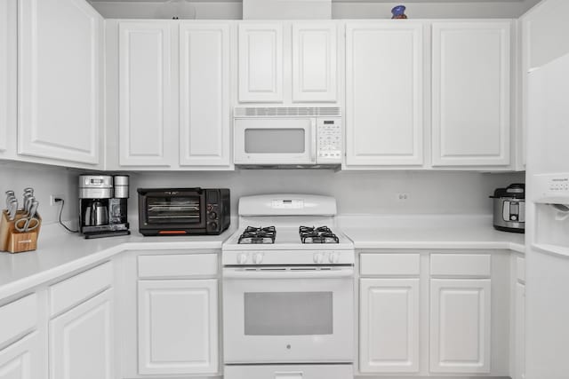 kitchen featuring white cabinetry and white appliances