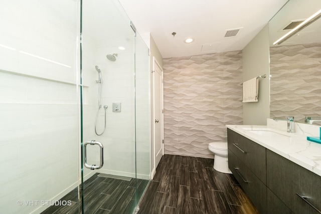 bathroom featuring tile walls, toilet, walk in shower, and vanity