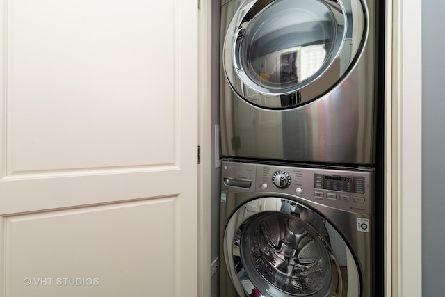 clothes washing area featuring stacked washing maching and dryer