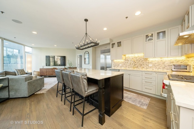 kitchen with white cabinetry, light wood-type flooring, a center island, and high end appliances