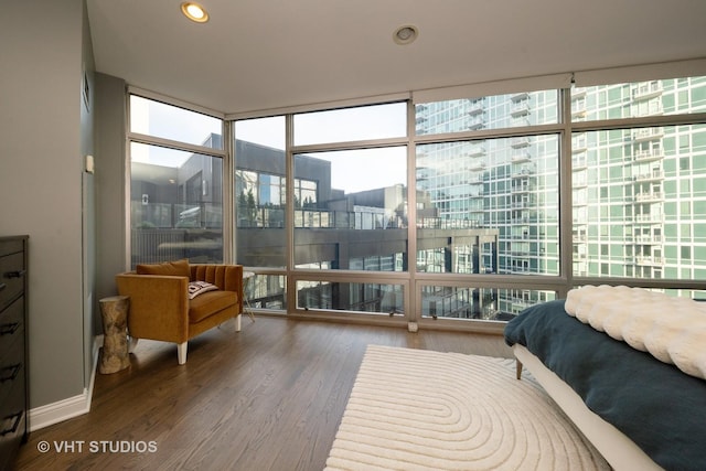 bedroom featuring expansive windows and dark hardwood / wood-style flooring