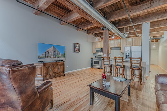 living room featuring beamed ceiling, light wood-type flooring, and wooden ceiling