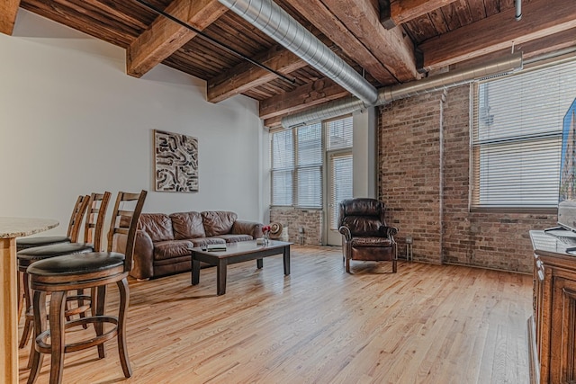 living room featuring beam ceiling, wooden ceiling, brick wall, and light wood-type flooring