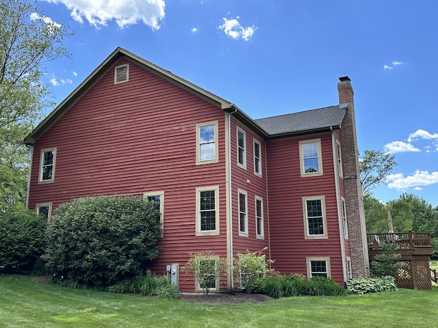 view of home's exterior featuring a lawn and a deck