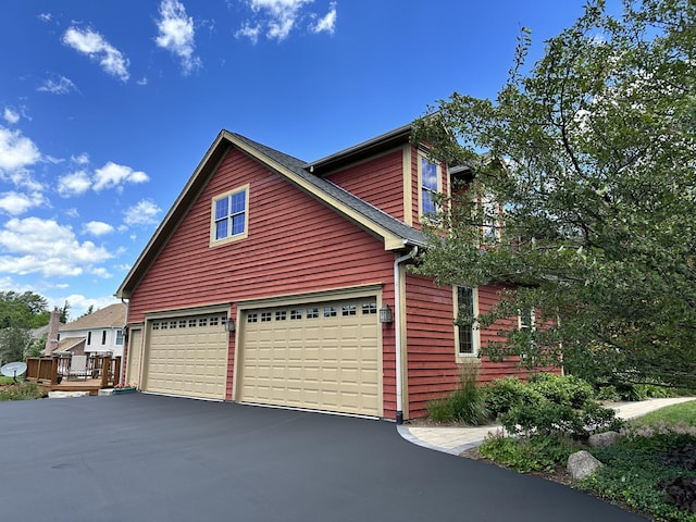 view of home's exterior featuring a garage and a wooden deck