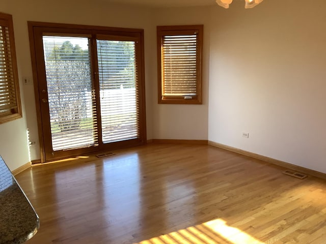 unfurnished room featuring wood-type flooring and a chandelier