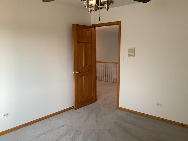 carpeted spare room with a chandelier