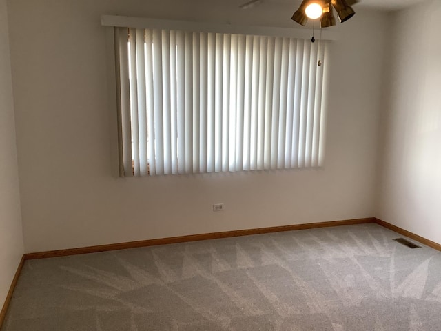 carpeted spare room with ceiling fan