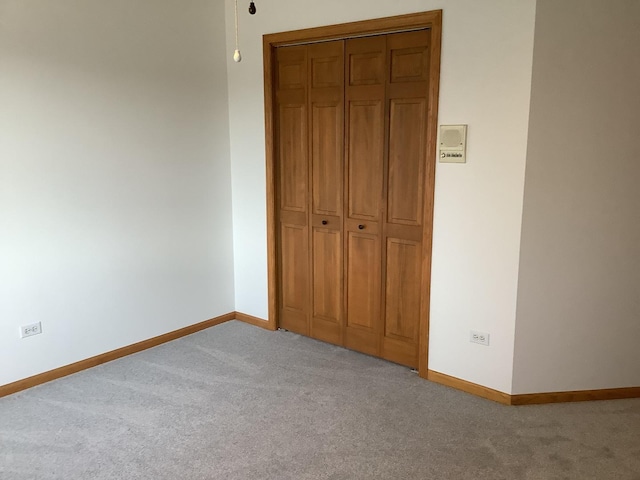 unfurnished bedroom with light carpet and a closet