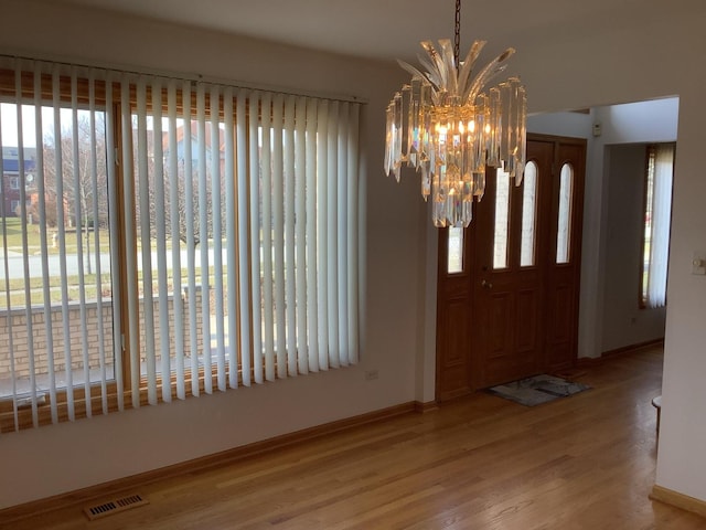 entrance foyer with hardwood / wood-style flooring and a notable chandelier