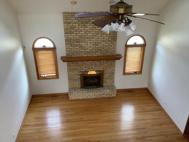 unfurnished living room with ceiling fan, light hardwood / wood-style floors, and a fireplace