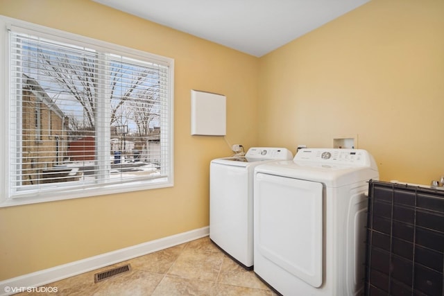 clothes washing area featuring light tile patterned floors and independent washer and dryer