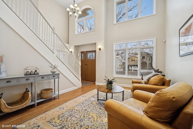 living room featuring a chandelier, wood-type flooring, and a high ceiling