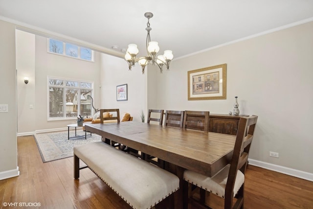 dining room with a chandelier, ornamental molding, and hardwood / wood-style flooring