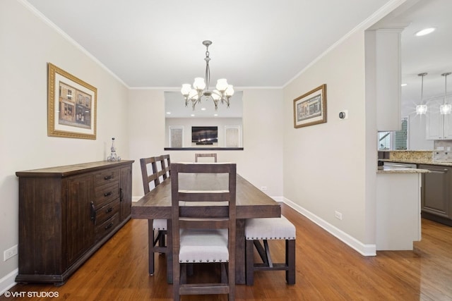 dining room featuring hardwood / wood-style flooring, ornamental molding, and an inviting chandelier