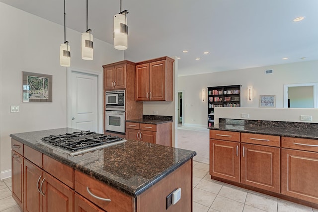 kitchen featuring hanging light fixtures, a center island, light tile patterned floors, and stainless steel appliances