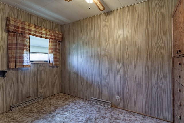 spare room featuring ceiling fan and wooden walls