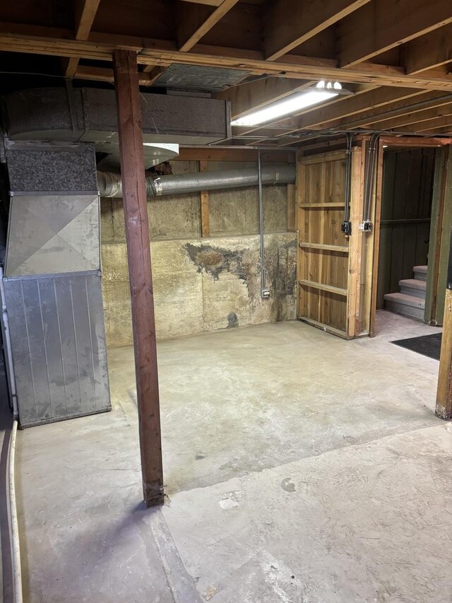 basement featuring wooden walls and gas water heater