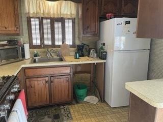 kitchen with sink, stove, and white refrigerator