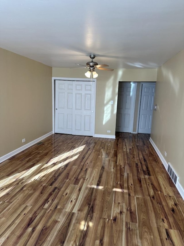 unfurnished bedroom featuring ceiling fan and dark hardwood / wood-style floors