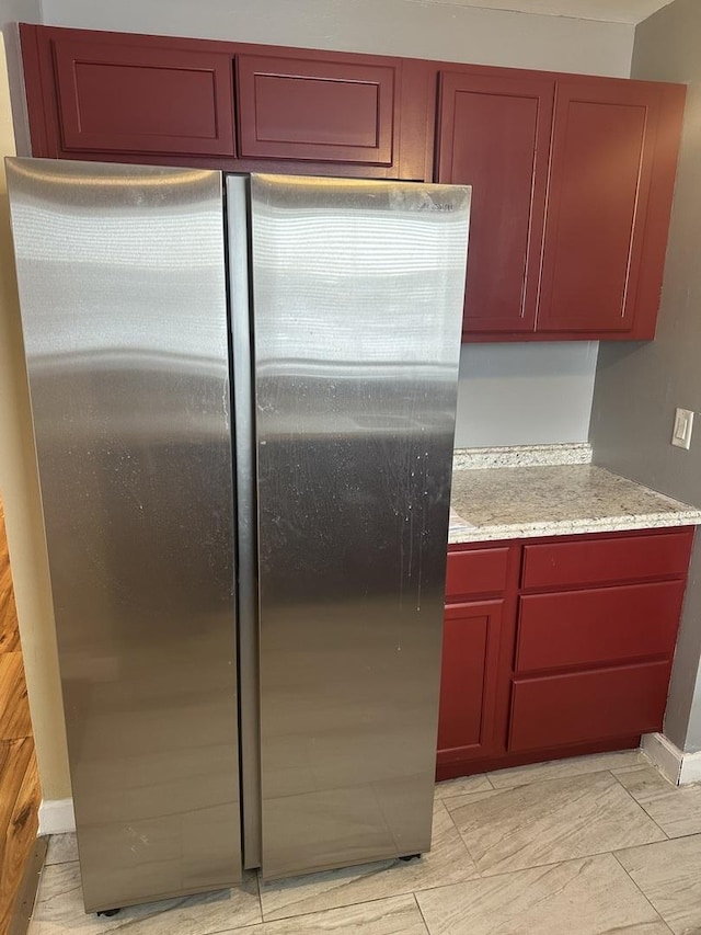 kitchen with stainless steel refrigerator and light stone counters