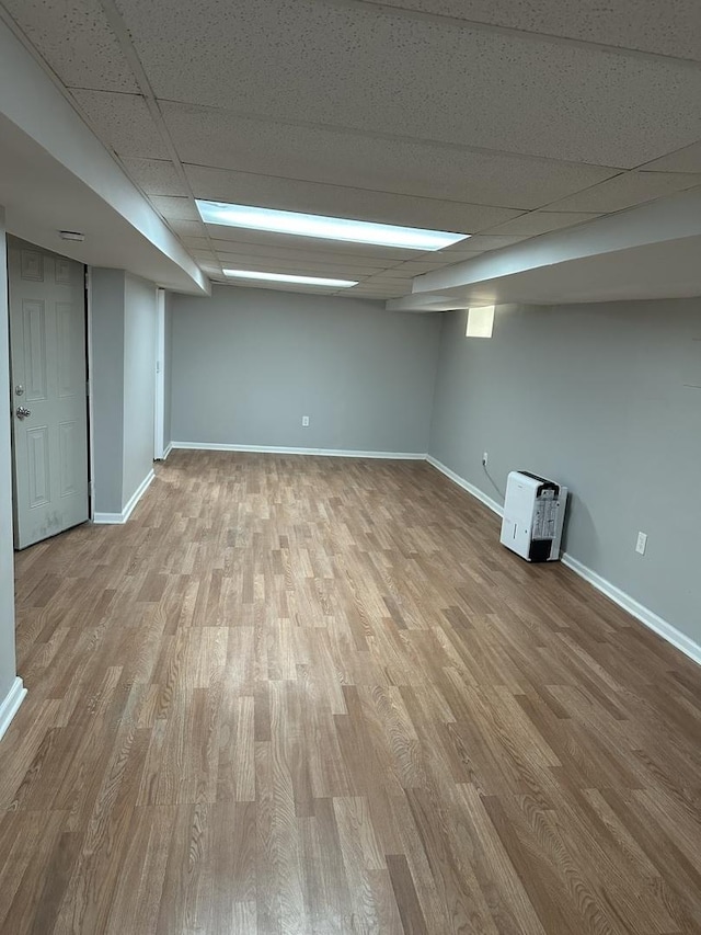 basement with a drop ceiling and light wood-type flooring