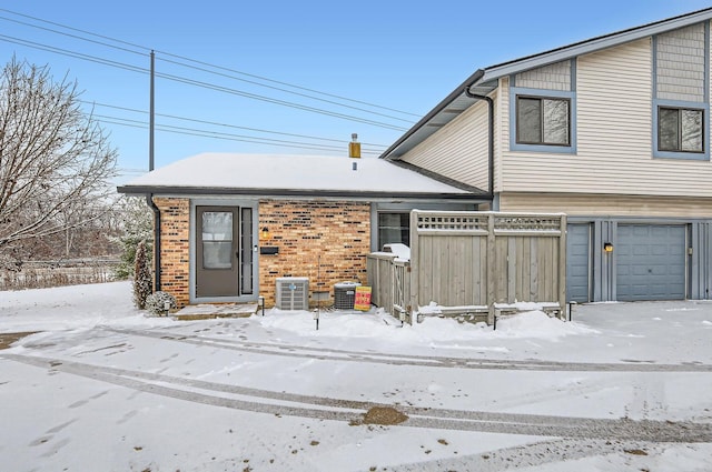 exterior space with a garage and central AC