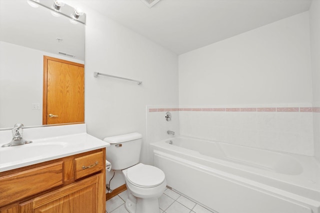 bathroom featuring tile patterned floors, vanity, a bath, and toilet