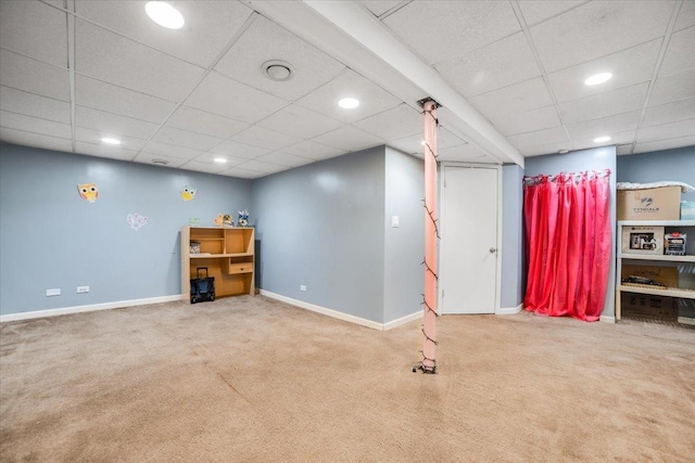 basement with carpet floors and a paneled ceiling