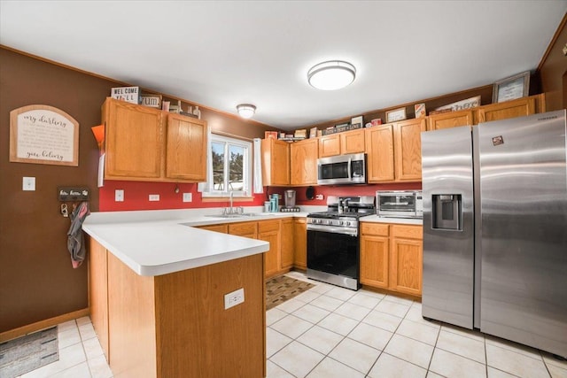 kitchen featuring appliances with stainless steel finishes, sink, light tile patterned floors, and kitchen peninsula