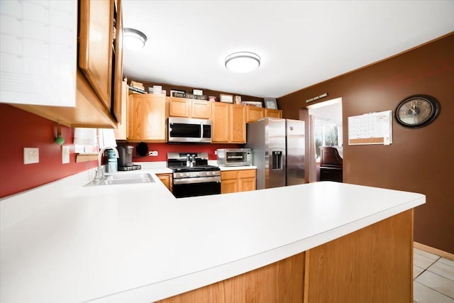 kitchen featuring stainless steel appliances, kitchen peninsula, and sink