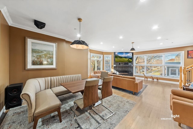 dining room with crown molding and light hardwood / wood-style flooring