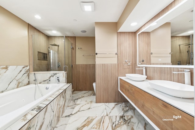 bathroom with vanity and shower with separate bathtub