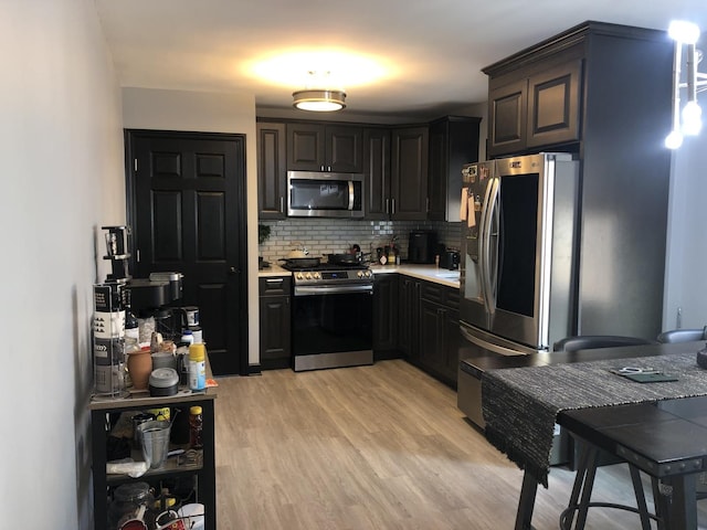 kitchen featuring appliances with stainless steel finishes, tasteful backsplash, and light hardwood / wood-style floors