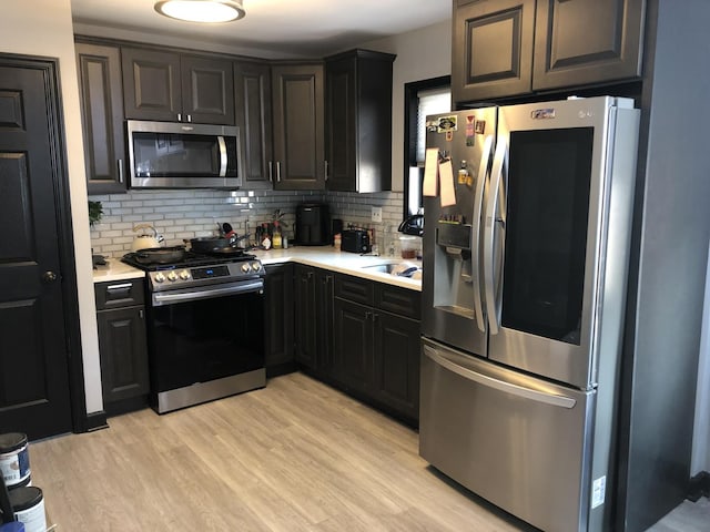 kitchen featuring tasteful backsplash, stainless steel appliances, and light hardwood / wood-style floors