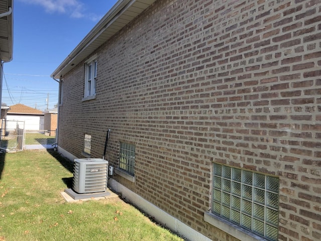 view of side of home with a lawn and cooling unit