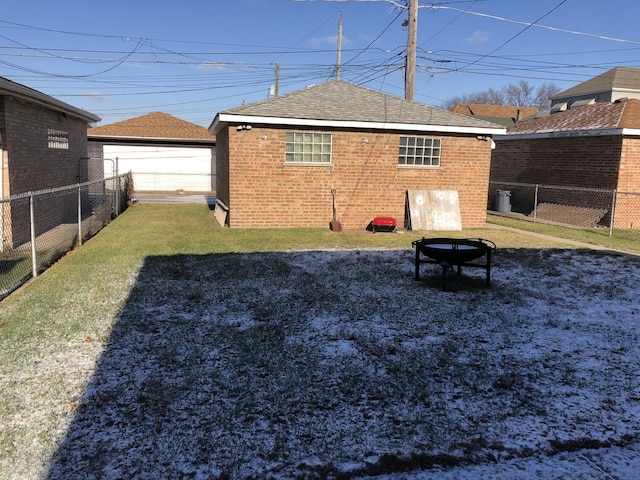 rear view of house featuring a lawn and a fire pit