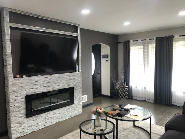 living room featuring hardwood / wood-style floors and a stone fireplace