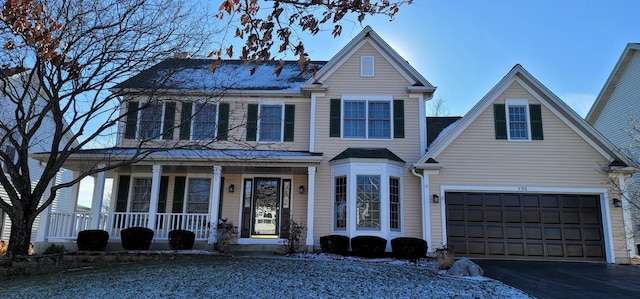 view of front of home featuring a porch and a garage