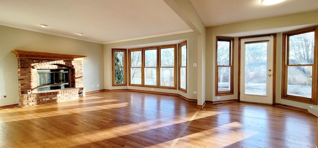 unfurnished living room featuring a fireplace, crown molding, and light hardwood / wood-style flooring