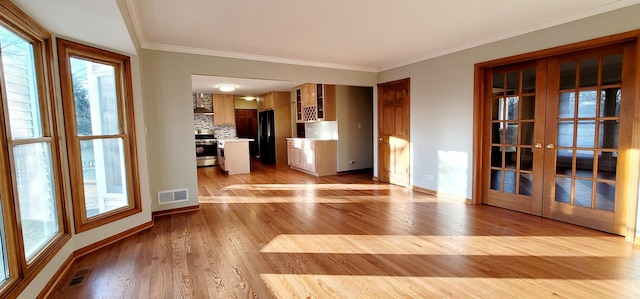 unfurnished living room featuring french doors, light hardwood / wood-style floors, and ornamental molding